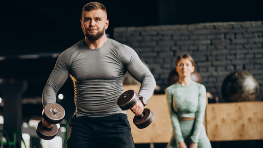 Man lifting dumbbells in a modern fitness space, rebuilding strength and focus to beat workout burnout and regain motivation.