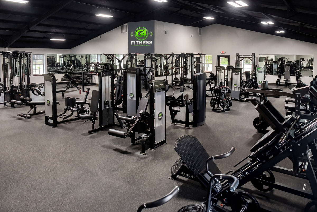 Open training floor at G4 Fitness lined with black selectorized strength machines, weight benches and a leg press, with the G4 Fitness logo on the far wall